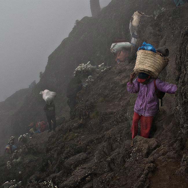 Porters carrying loads. (Photo: Adam Angel)